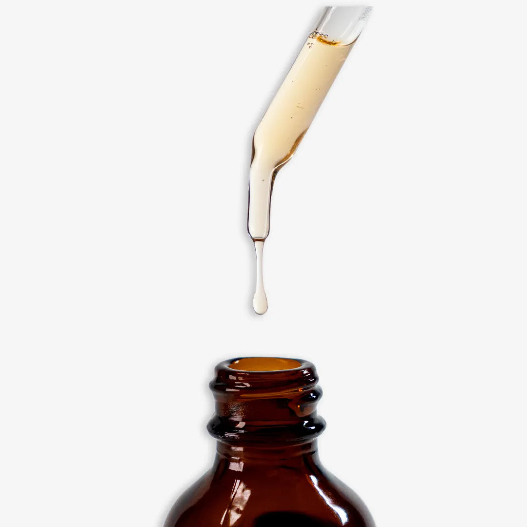 Drops of Efecto Espejo Hair Serum for smooth, shiny, and frizz-free hair.